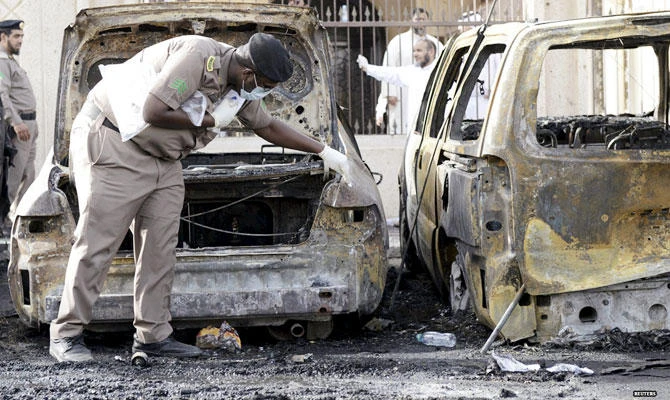 A policeman carries out an inspection after a car exploded near the Shi'ite al-Anoud mosque in Saudi Arabia's Dammam May 29, 2015. (REUTERS)