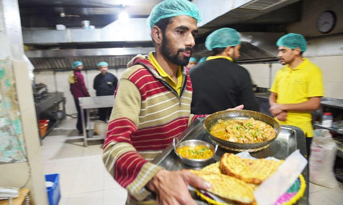 This photo taken on January 18, 2019 shows a waiter carrying prepared dishes from the kitchen of Chattha's, one of Islamabad's best-known restaurants. (AFP)