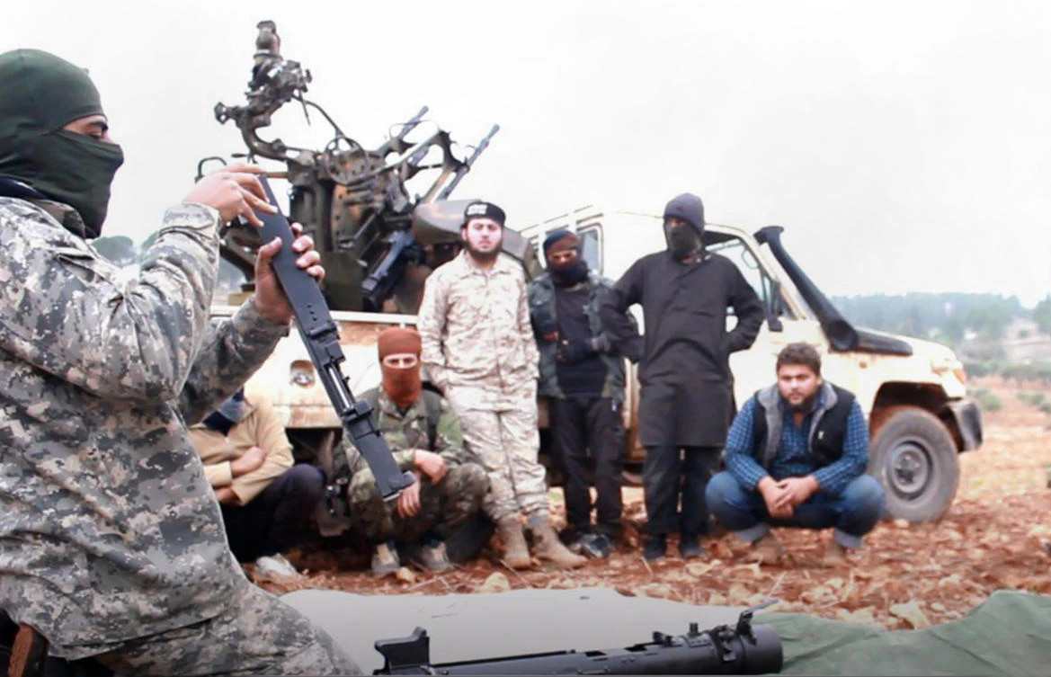This photo released Tuesday, Nov. 13, 2018 by the Al-Qaeda-affiliated Ibaa News Agency, shows Al-Qaeda-linked militants learning how to use a heavy weapon in the countryside of Idlib, Syria. (Ibaa News Agency/AP)