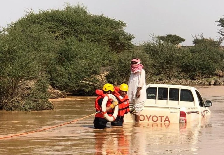 Civil Defense members help rescue a vehicle in Al-Muwayh. (Civil Defense)