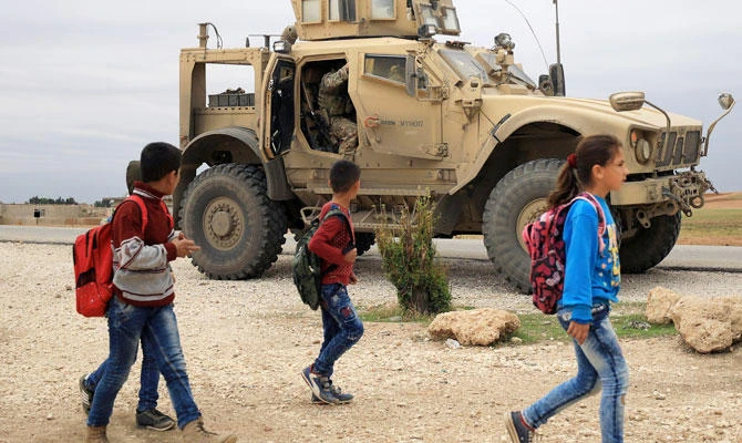 Syrian schoolchildren walk as U.S. troops patrol near Turkish border in Hasakah, Syria Nov. 4, 2018. (REUTERS)