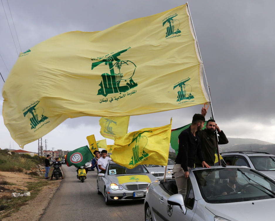 A Hezbollah supporter holds the group’s flag in Marjayoun, Lebanon, on May 7, 2018. Mroueh said she understood Hezbollah supporters’ pain as someone from the south. (Reuters file)