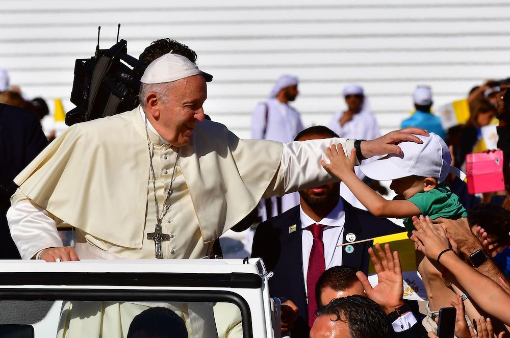 Pope Francis blesses a child as he arrives to lead mass for an estimated 170,000 Catholics at the Zayed Sports City Stadium. (AFP)
