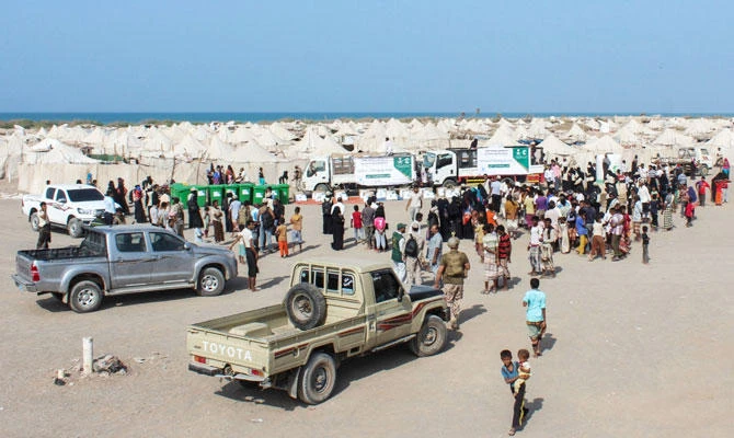 Displaced Yemenis gather to receive Saudi-provided food aid at a camp for the displaced in the Khokha district of the western province of Hodeida, on January 21, 2019. (AFP)