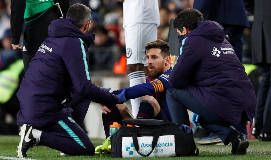 Barcelona's Lionel Messi receives treatment after sustaining an injury during Saturday's football match between C Barcelona and Valencia at Camp Nou, Barcelona. (REUTERS/Albert Gea)