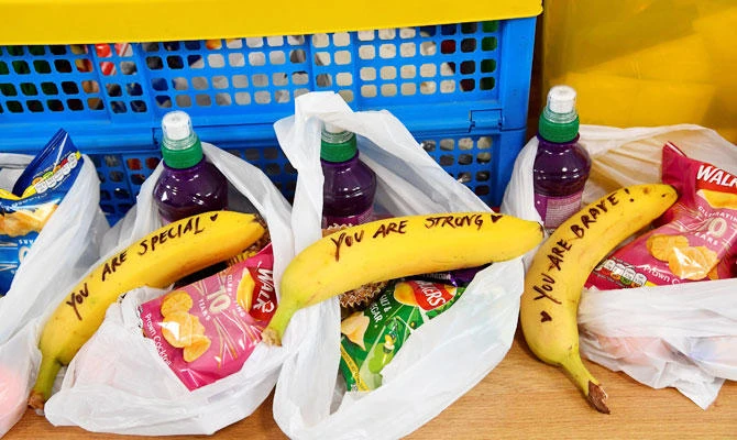 Messages are pictured, written on bananas by Meghan, Duchess of Sussex when she was helping to prepare food parcels to go in the charity outreach van during the Royal couple's visit to One25 charity in Bristol, south west England on February 1, 2019. (AFP)