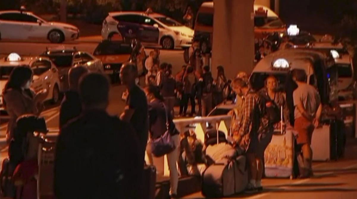 Travelers stay outside Brisbane International Airport in this video grab after the airport on Saturday, February 2. (Australian Broadcasting Corporation via AP)