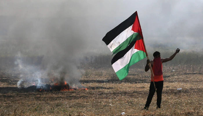 Protester holding Palestinian flags during protest at Israel-Gaza border, in the southern Gaza Strip. (Photo: Reuters)
