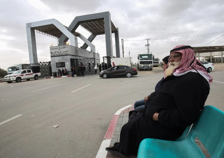 Palestinians sit waiting at the Rafah border crossing with Egypt, in the southern Gaza Strip. (File photo/AFP)