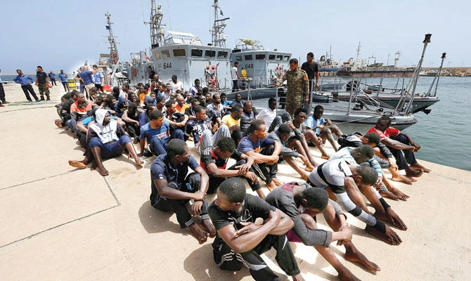 Migrants sit at a naval base after being rescued by the Libyan coast guard in Tripoli, on Sunday. (Reuters)