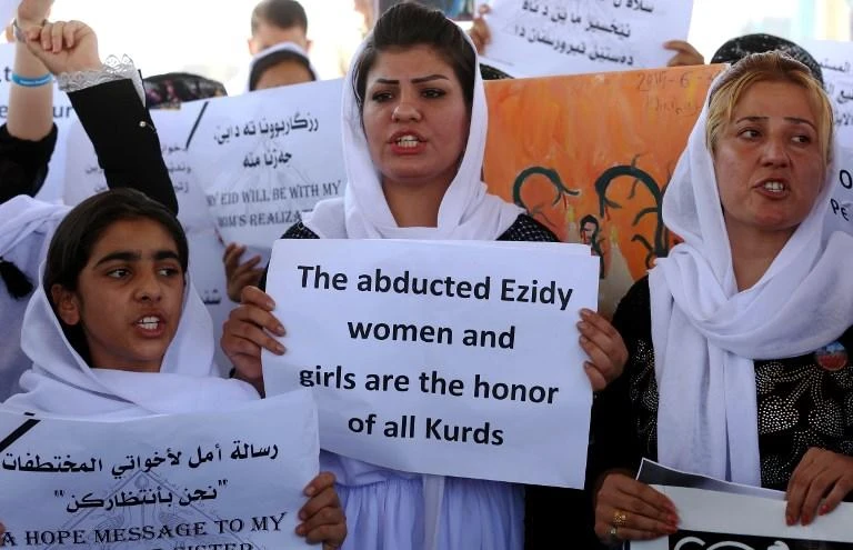 Yazidi women hold placards during a protest outside the United Nations office in Erbil on August 2, 2015 in support of women from their community who were kidnapped by Daesh militants. (AFP)