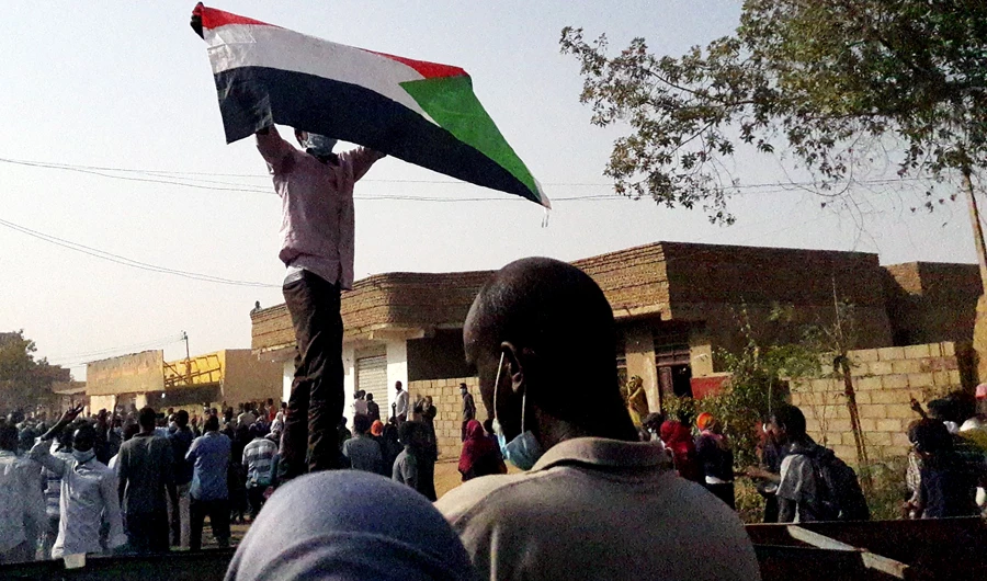 A Sudanese protester waves a national flag during an anti-government demonstration in the capital Khartoum's twin city of Omdurman on Jan. 31, 2019. (AFP)