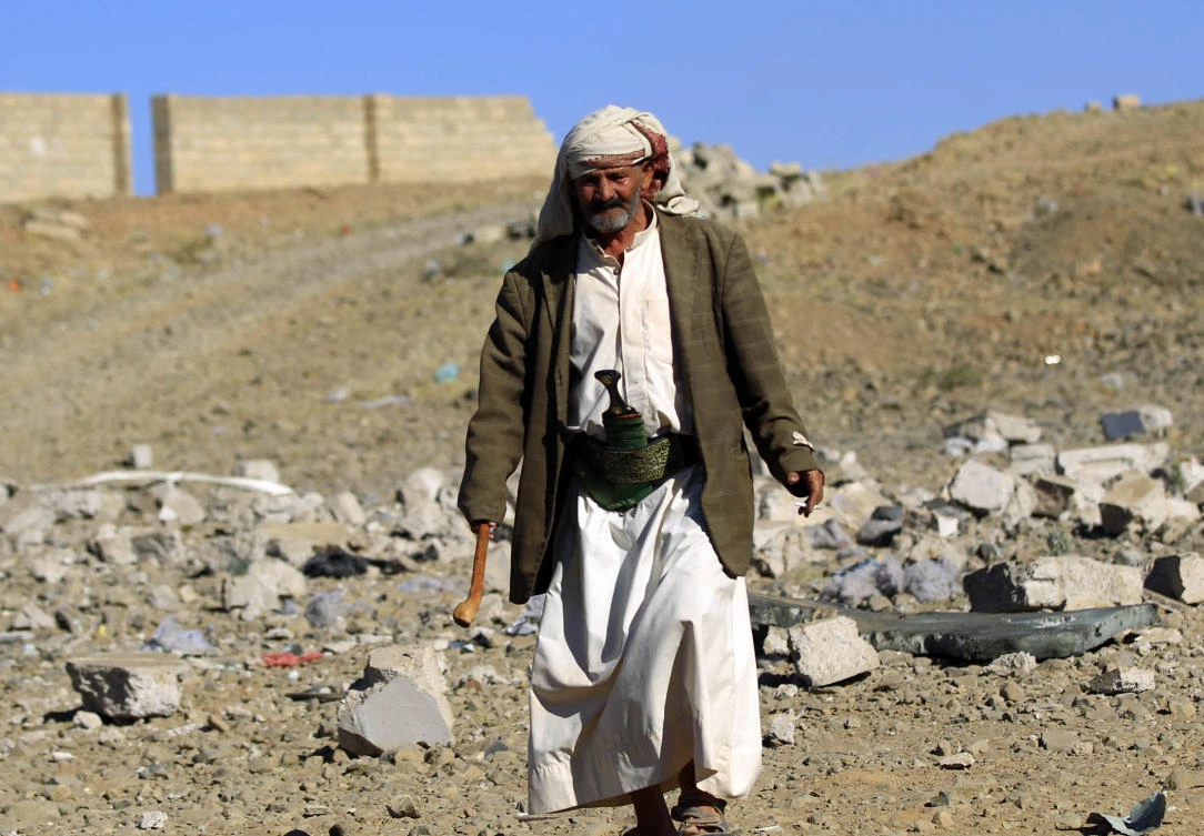 A Yemeni man walks above debris of a building destroyed in Saudi-led air strikes in Yemen's capital Sanaa on February 1, 2019. (AFP)
