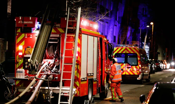 Firefighters are seen near a building that caught fire in the 16th arrondissement in Paris, on February 5, 2019. (AFP)
