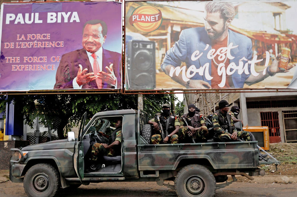 Cameroonian elite Rapid Intervention Battalion (BIR) members pas under a plazard of Cameroon President Paul Biya in the southwest city of Buea, Cameroon, in this October 4, 2018 photo. (REUTERS/Zohra Bensemra/File Photo)