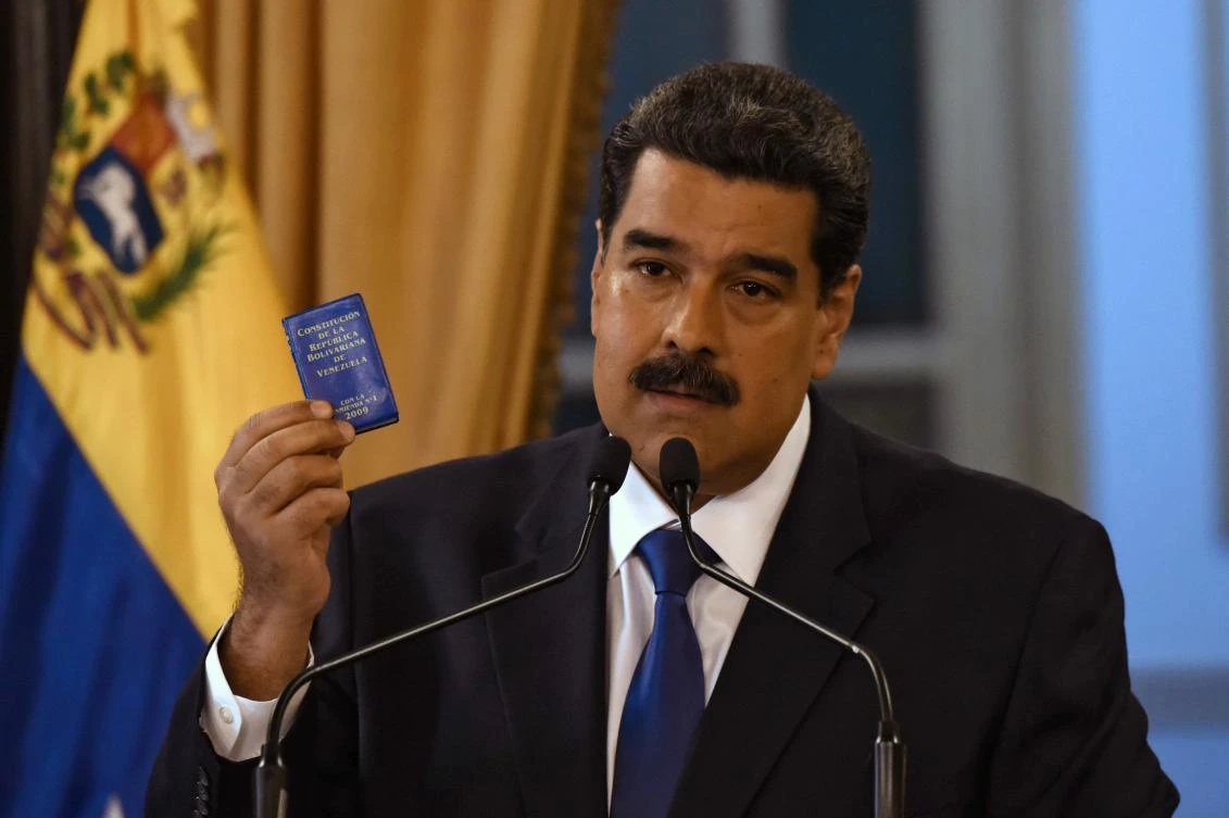 President Nicolas Maduro, brandishing the Constitution of the Bolivarian Republic of Venezuela, said Venezuela isn’t a nation of ‘beggars’ and won’t accept US humanitarian assistance. (AFP)