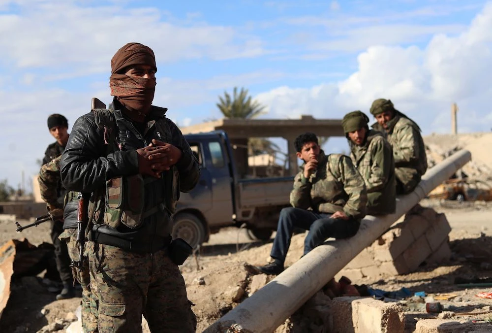 Fighters from the Syrian Democratic Forces (SDF) gather in the front line village of Baghouz in the countryside of the eastern Syrian Deir Ezzor province, on the border with Iraq, on February 2, 2019. (AFP)
