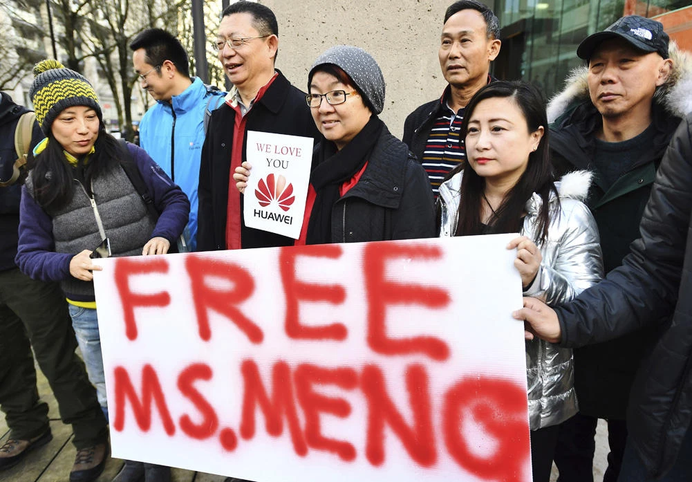 Supporters hold a sign of support for Meng Wanzhou, Huawei's chief financial officer prior to her bail hearing at a Vancouver, British Columbia courthouse on Dec. 10, 2018. (Jonathan Hayward/The Canadian Press via AP, File)