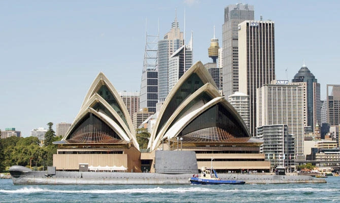 Former Royal Australian Navy submarine HMAS Onslow is towed past the Sydney Opera House on its way to be refitted at Garden Island naval base in this October 16, 2008 file photo. (REUTERS)