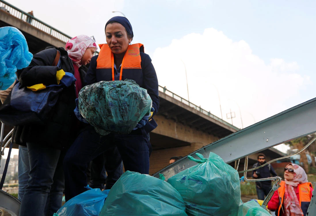 Young Egyptians trudge through mud to clean up Nile