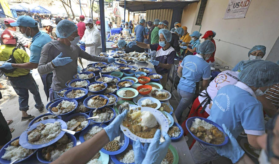 Volunteers prepare free lunches for Venezuelan migrants at the "Divina Providencia" migrant shelter in La Parada, near Cucuta, on the border with Venezuela, Colombia, on Feb. 11, 2019. (AP Photo/Fernando Vergara)