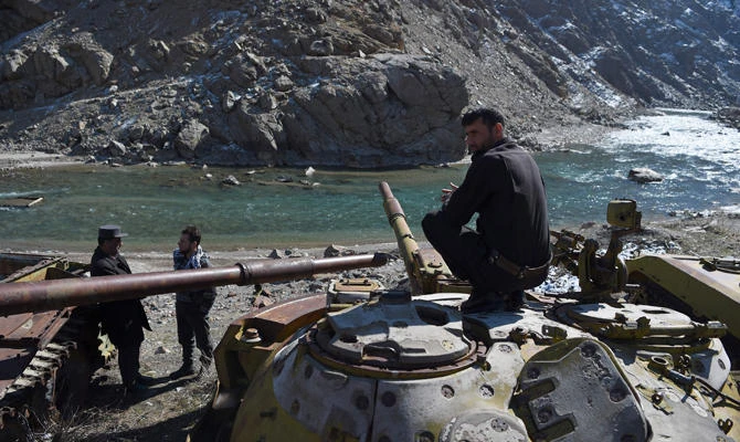 Afghan police gather near the remains of Soviet-era tanks in Panjshir province, north of the capital Kabul, on February 7, 2019. (AFP / Wakil Kohsar)