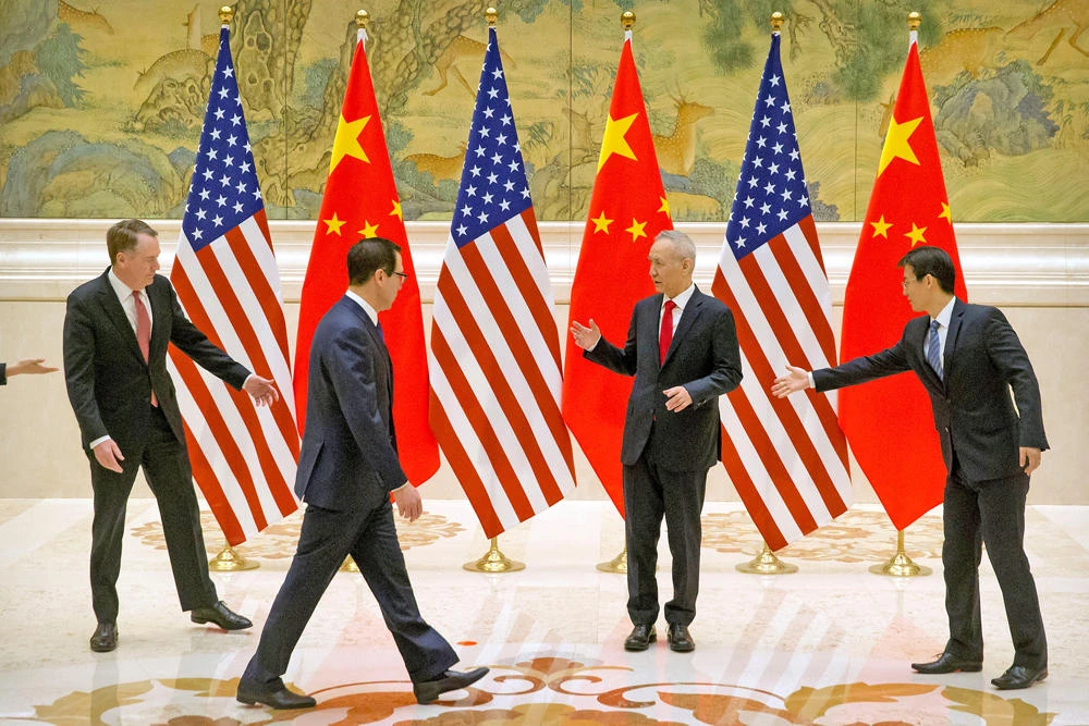 Aides gesture as US Trade Representative Robert Lighthizer, Chinese Vice Premier and lead trade negotiator Liu He, and US Treasury Secretary Steven Mnuchin line up for a photo before the opening session of trade negotiations at the Diaoyutai State Guesthouse in Beijing on Feb. 14, 2019. (Mark Schiefelbein/Pool via REUTERS)