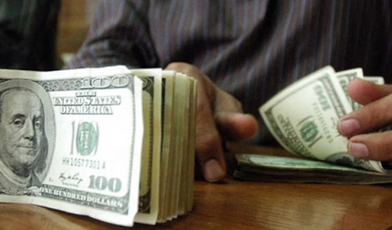 A Pakistani currency dealer counts US dollars at a currency exchange shop. (AFP/file)