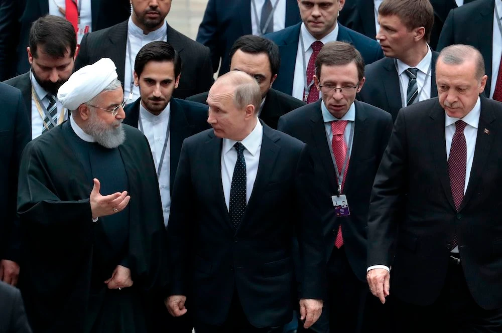 Russian President Vladimir Putin, Turkish President Recep Tayyip Erdogan and Iranian President Hassan Rouhani walk during a trilateral meeting on Syria in the Black Sea resort of Sochi on February 14, 2019. (AFP)