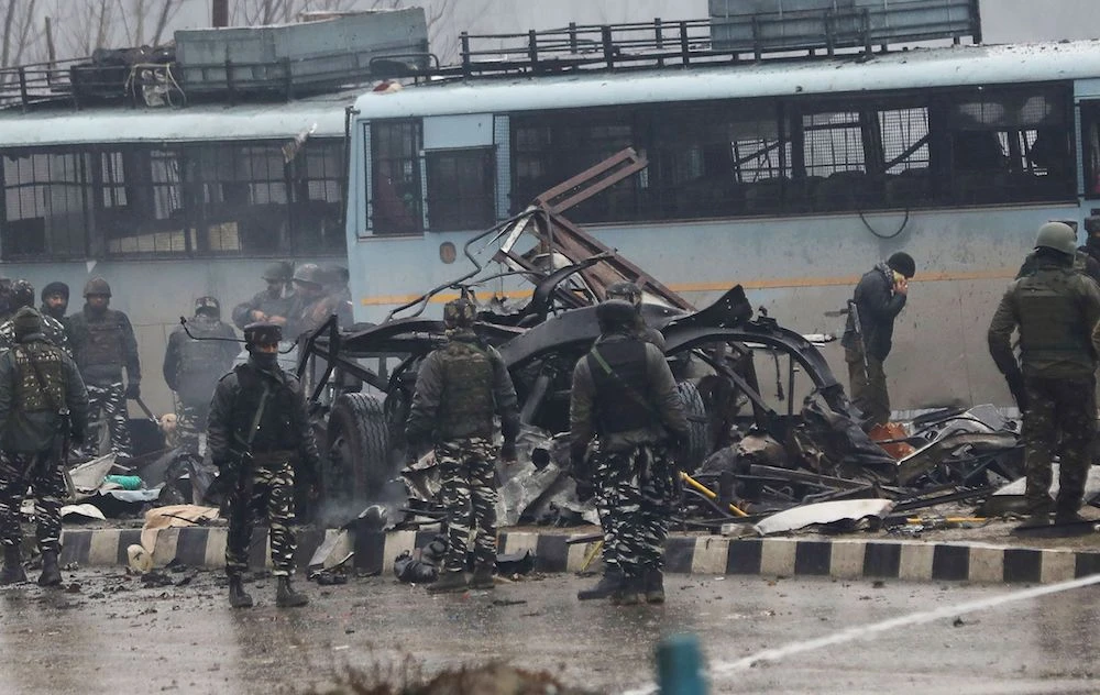 Indian security forces inspect the remains of a bus following an attack on a paramilitary Central Reserve Police Force (CRPF) convoy that killed at least 25 troopers and injured several others near Awantipora town, about 30 kms South of Srinagar, in Lethpora on February 14, 2019. (AFP)