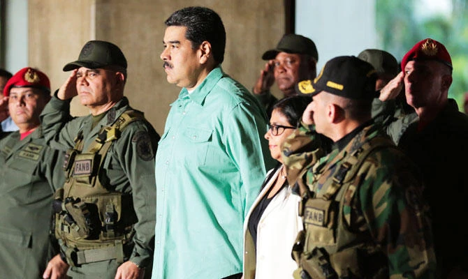 Handout picture released by the Venezuelan Presidency showing Venezuela's President Nicolas Maduro (C), Venezuelan Defence Minister Vladimir Padrino (C-L) and Venezuelan Vice-President Delcy Rodriguez (C-R) during the closing ceremony and balance of military exercices in Caracas, on February 15, 2019. (AFP)
