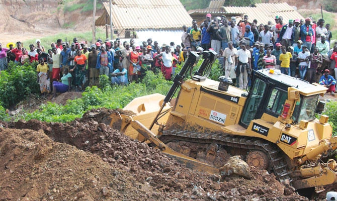 Machinery is used to clear the ground near a mineshaft where about 40 artisanal miners are feared dead after rains flooded the mines while they were underground on the outskirts of Kadoma town about 200 kilometres west of Harare, Zimbabwe, Friday, Feb, 15, 2019. (AP)
