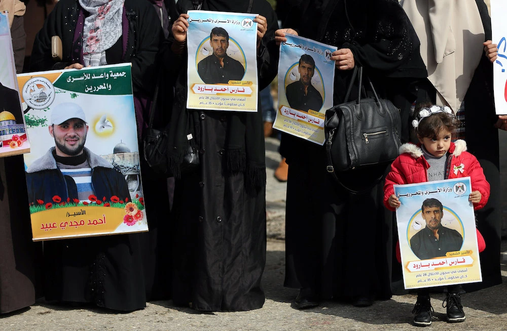 Families of Palestinian prisoners held in Israeli jails hold their pictures during a recent protest. (Reuters)