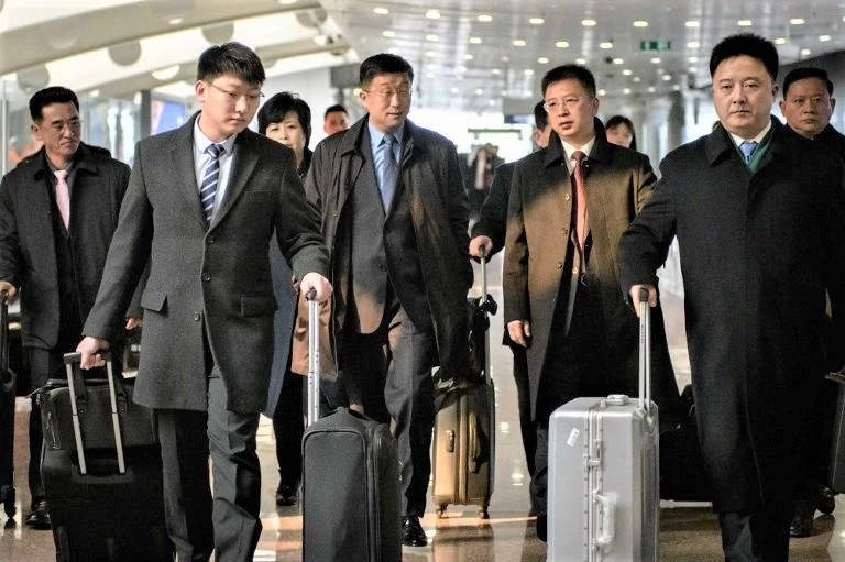 North Korean negotiator Kim Hyok Chol, center in blue tie, at Beijing international airport after disembarking an Air Koryo flight from Pyongyang on Tuesday, February 19. (AFP)