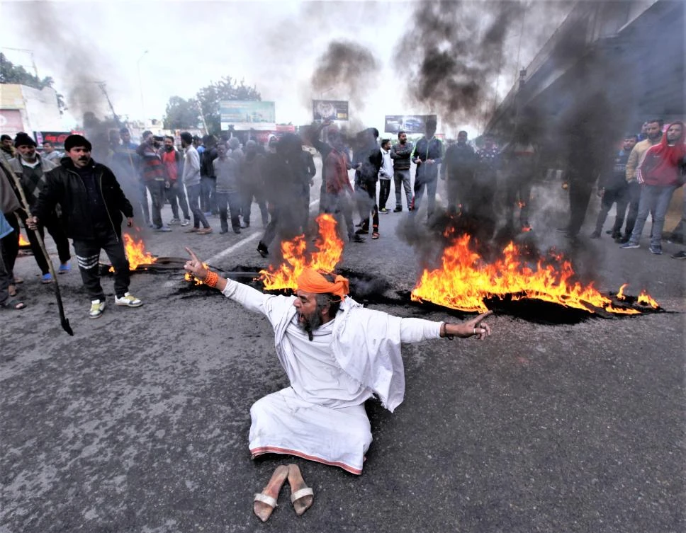 Protesters burn tires and shout slogans during a protest in Jammu on February 15, a day after an attack on a paramilitary Central Reserve Police Force in Kashmir. (AFP)