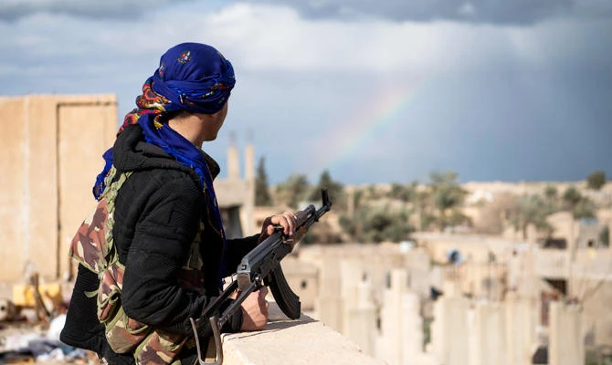 A member of the Syrian Democratic Forces (SDF) stands guard on top of a building on February 17, 2019, in the frontline Syrian village of Baghuz. (AFP)