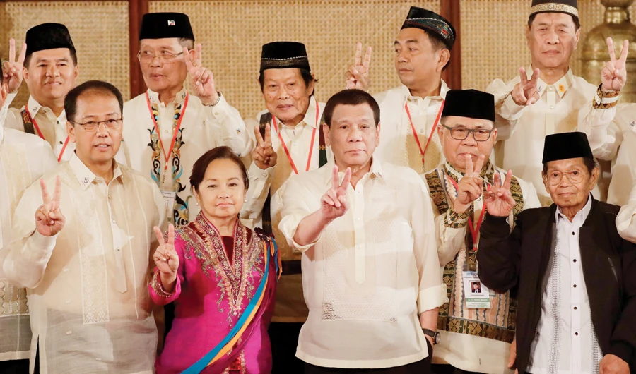 President Rodrigo Duterte, political leaders and officials flash the peace sign following Friday’s oath-taking ceremony in Manila. (AP)