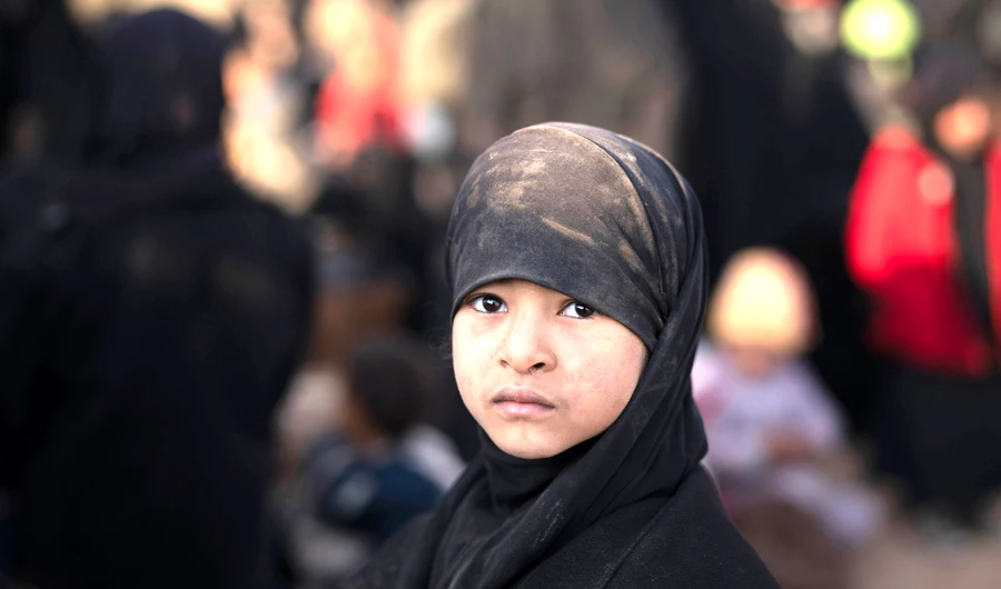 A girl waits to be screened by US-backed Syrian Democratic Forces female fighters after being evacuated out of the last territory held by Daesh militants, near Baghouz, eastern Syria, on Friday. (AP)