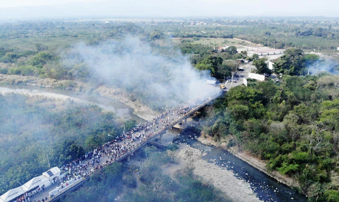 Aerial photo showing smoke billowing from trucks which were carrying humanitarian aid and which were set ablaze on the Francisco de Paula Santander International Brige between Cucuta in Colombia and UreÒa (R) in Venezuela, on February 23, 2019. (AFP)
