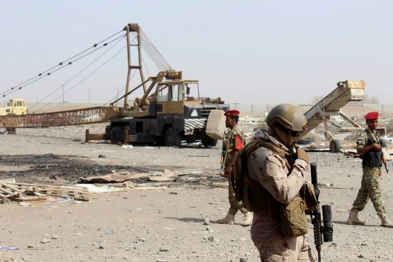 The Red Sea Mills contain grains that feed 30 million Yemenis. Above, soldiers aligned with the coalition stand outside a damaged warehouse belonging to the Red Sea Mills. (AFP/File)