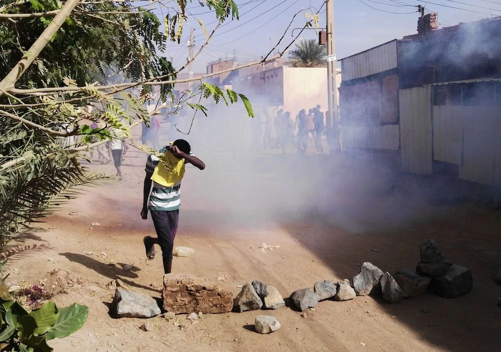 A Sudanese protester covers his face from tear gas during an anti-government demonstration in the Sudanese capital Khartoum's district of Burri on February 24, 2019. (AFP)