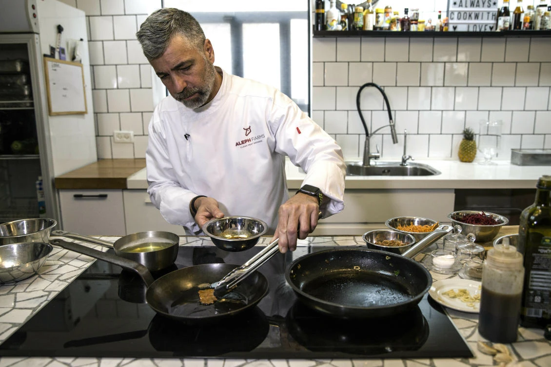 Chef Amir Ilan prepares a lab-grown steak during a presentation by the Israeli company Aleph Farms, in Jaffa, Israel. (AP/Tsafrir Abayov)