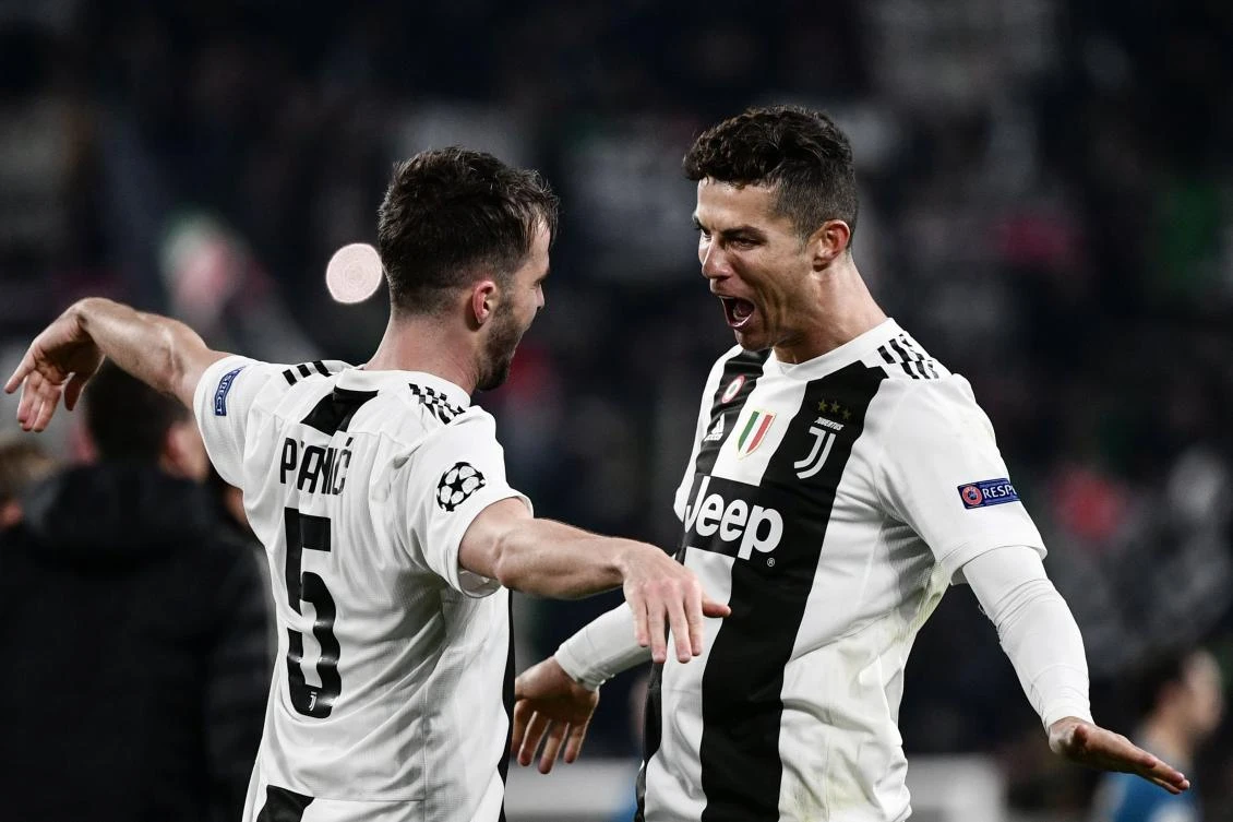 TOPSHOT - Juventus' Bosnian midfielder Miralem Pjanic (L) embraces Juventus' Portuguese forward Cristiano Ronaldo at the end of the UEFA Champions League round of 16 second-leg football match Juventus vs Atletico Madrid on March 12, 2019 at the Juventus stadium in Turin. / AFP / Marco BERTORELLO