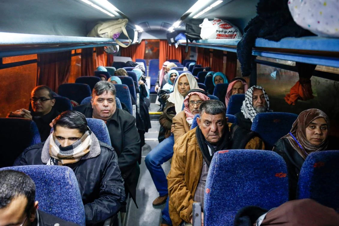 Palestinians Muslim pilgrims sit in a bus at the Rafah border crossing between the Gaza Strip and Egypt on March 3, 2019, before crossing to depart for Makkah to perform Umrah. (AFP)