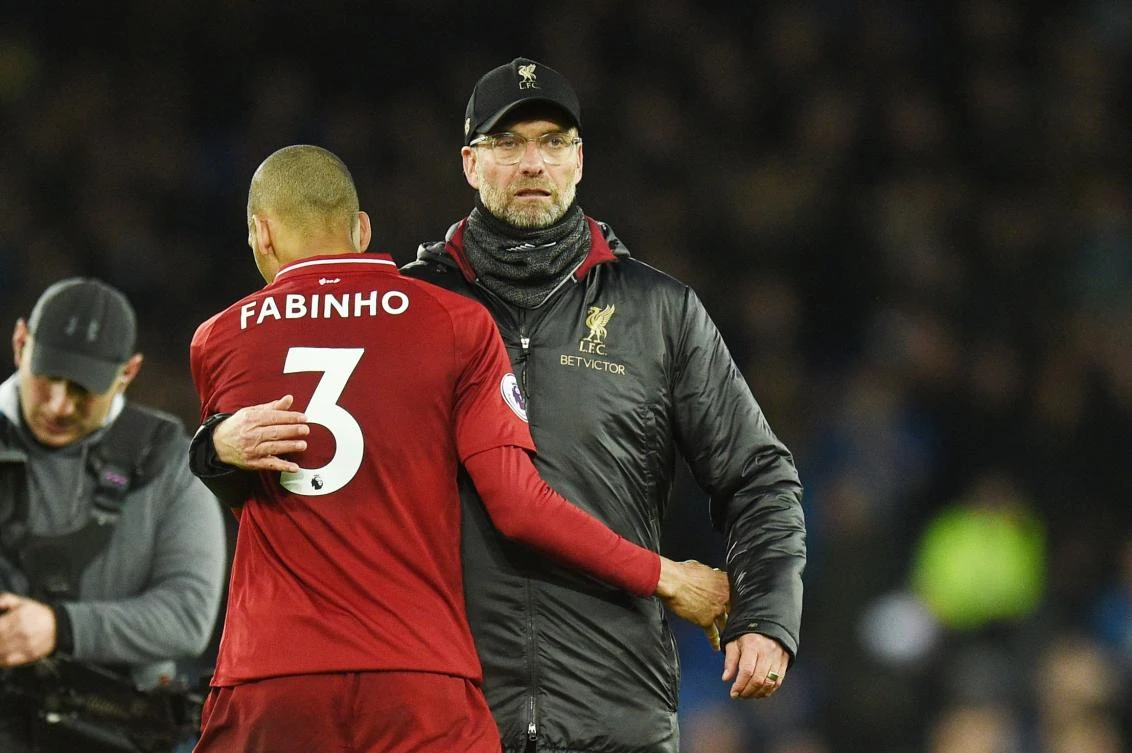 Liverpool's Brazilian midfielder Fabinho (L) is embraced by Liverpool's German manager Jurgen Klopp after drawing the English Premier League football match between Everton and Liverpool at Goodison Park. (AFP)