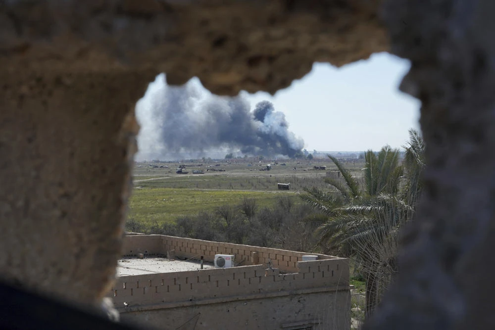 Columns of black smoke billow from the last small piece of territory held by Daesh militants as US-backed fighters pounded the area with artillery fire and occasional airstrikes in Baghouz, Syria, on March 3, 2019. (AP Photo/Andrea Rosa)