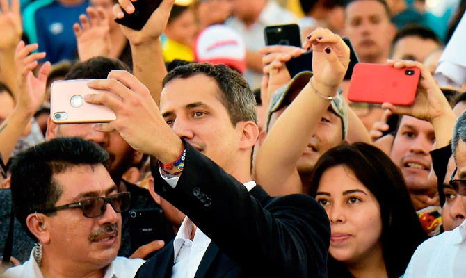 Venezuelan opposition leader and self-proclaimed acting president Juan Guaido makes a selfie with supporters after meeting with Ecuadorean President Lenin Moreno in Salinas, Ecuador on March 2, 2019. (AFP)