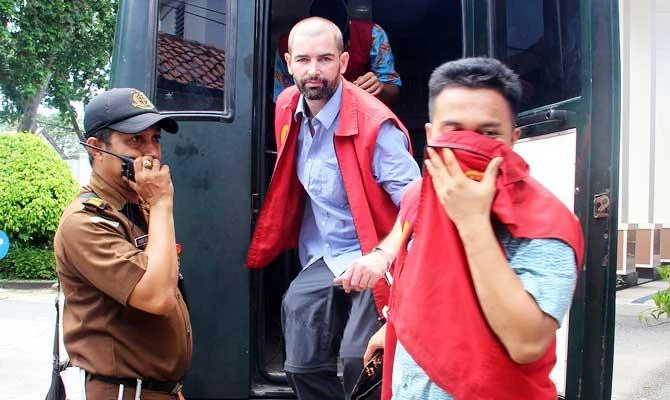 French national Felix Dorfin (C) is guarded by Indonesian officers as he arrives at a court for his trial in Mataram on February 21, 2019. (AFP)