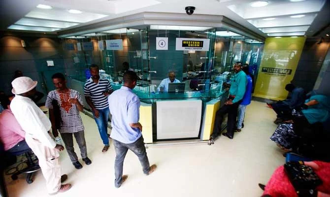 Sudanese people que at a foreign exchange dealer in central Khartoum on October 12, 2017, after the lifting of the US trade embargo came into effect. (AFP)