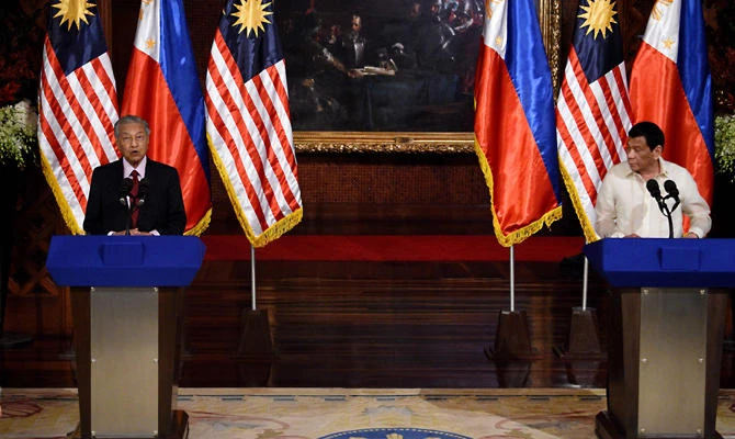 Philippines' President Rodrigo Duterte (R) listens as Malaysia's Prime Minister Mahathir Mohamad speaks during their joint statements in Manila on March 7, 2019. (AFP / Ted ALJIBE)